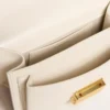 Geanta Venezia mică din piele rigidă de culoarea untului, cu eșarfă împletită și două pandantive