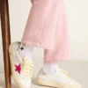 May Young cu stea sclipitoare fucsia și bandă metalică din piele pe călcâi