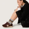 Modelul Marathon pentru femei, cu partea superioară din satin maro și stea din piele platină