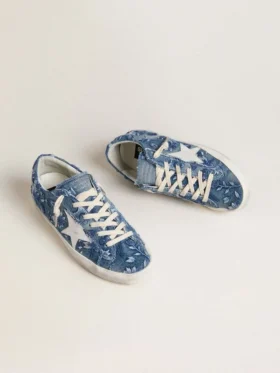 Modelul Super-Star LTD pentru femei, din denim albastru deschis, cu o stea din piele albă și flori brodate