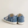 Modelul Super-Star LTD pentru femei, din denim albastru deschis, cu o stea din piele albă și flori brodate